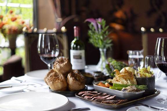 Chateaubriand beef tenderloin dish with accompaniments and red wine in restaurant private dining room, Edinburgh 