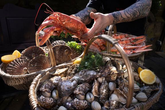 Chef at the Witchery carrying 2 baskets of food