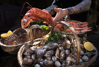Chef at the Witchery carrying 2 baskets of food