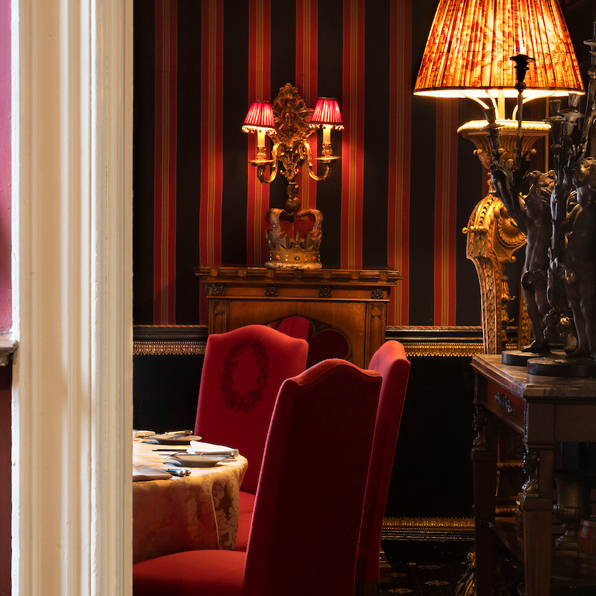 Antique lamps light up the Stuart private dining room with its dramatic red, black and gold décor and luxurious furnishings