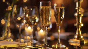Champagne flutes filled with champagne, silver cutlery and candlesticks on a private dining room table in Prestonfield 