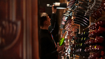 Wine racks and sommelier holding a bottle in the cellar at the Best Edinburgh restaurant for fine wines 
