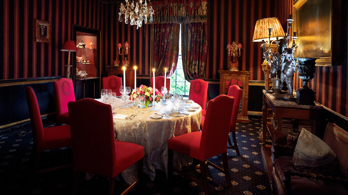 Candles lit and table set with red velvet background in The Stuart private dining room in Edinburgh at Prestonfield House 