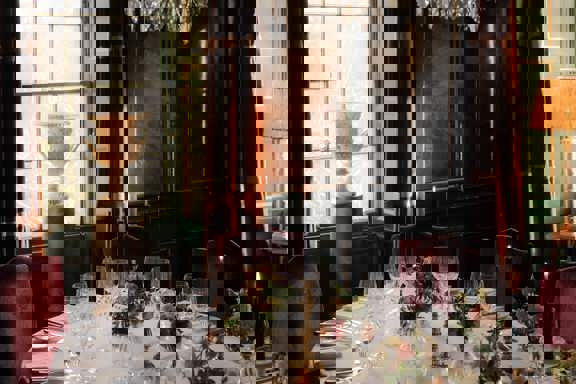 A grand dinner table set with candles and flowers in Prestonfield's Italian Room for large group private dining in Edinburgh 